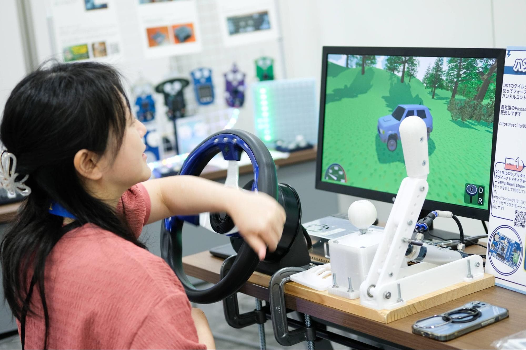 フォースフィードバックのハンドルを楽しむ参加者.jpg
