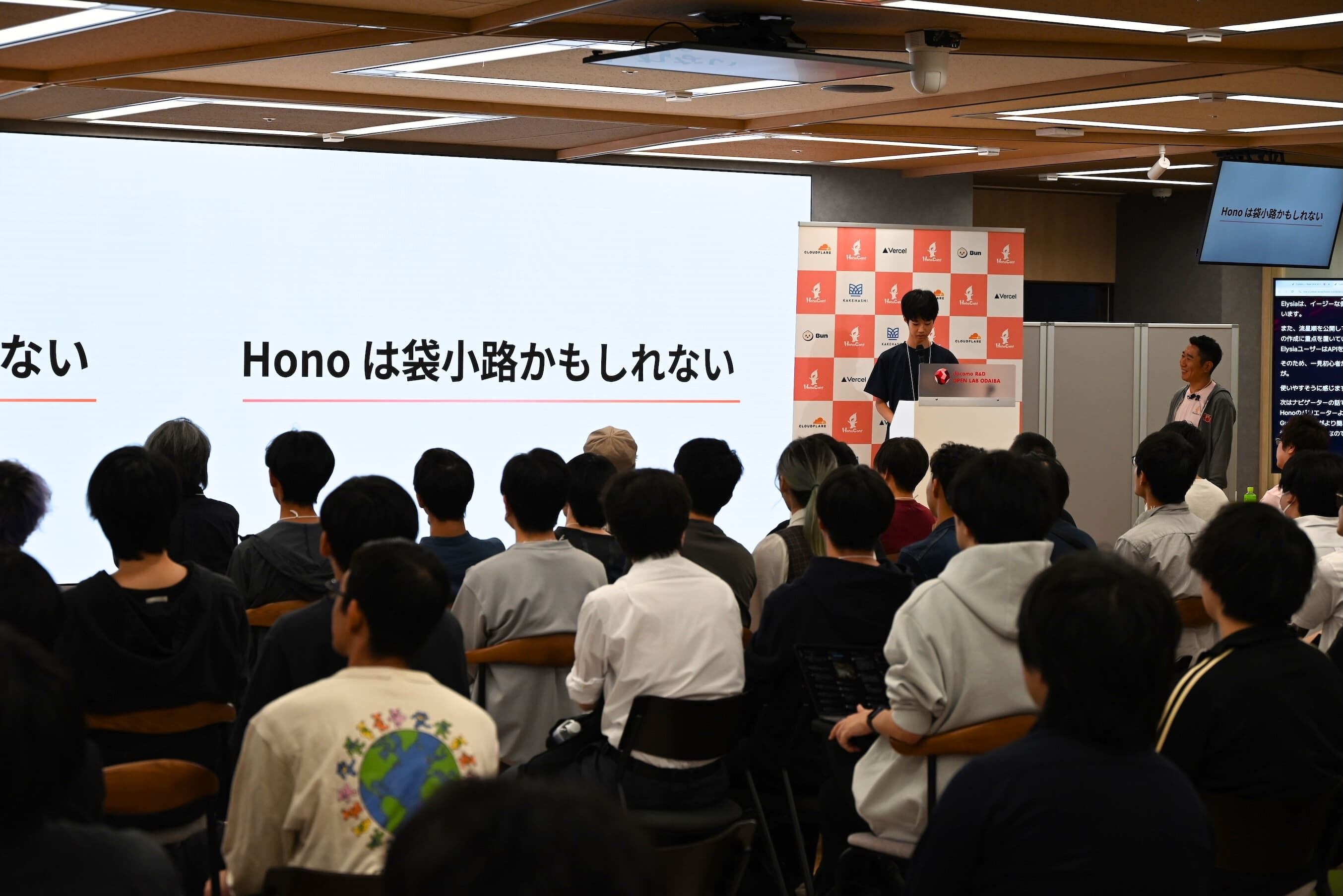 Honoは袋小路かもしれない、と話すnakasyou氏。ステージ脇でyusukebe氏が微笑んでいる。